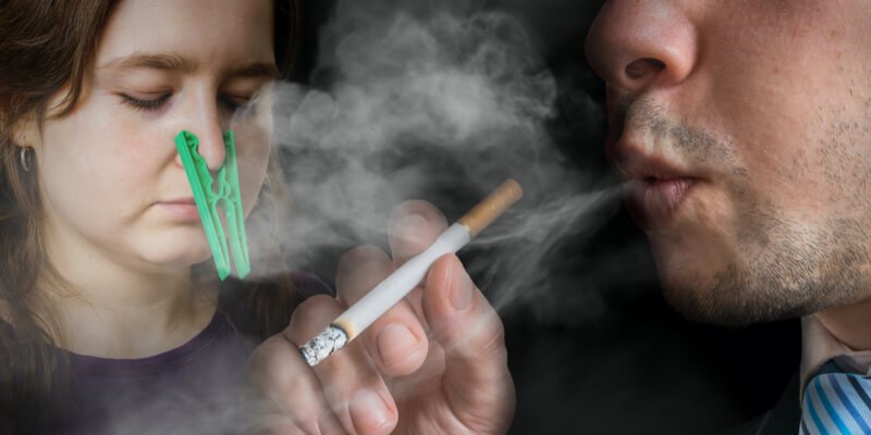 persona fumando y otra tapándose la nariz
